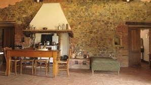 A rustic interior with a stone wall, wooden furniture, and a fireplace. - la Casa - Agriturismo With Pool Between Siena and Grosseto (Civitella Paganico)