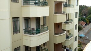 Un edificio residencial de varios pisos con balcones, ventanas y vistas del entorno.