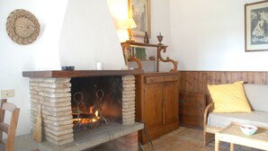 Una sala de estar acogedora con chimenea, muebles de madera y una estantería con adornos.