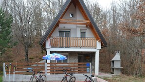 A lodge with a wooden balcony, bicycles parked in front, and a stone fireplace. - Chalet Katarina (Lovinac)