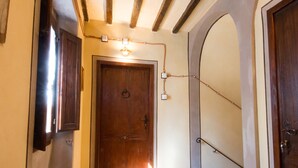 A hallway with wooden doors, a light fixture, and a tiled floor.