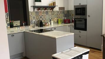 Frigorífico grande, microondas, placa de cocina y utensilios de cocina