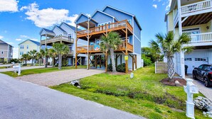 A beachfront property with multiple-story buildings, balconies, and a clear view of the ocean. - Beach Bliss & Pool Days Await! (Surf City)