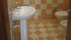 A bathroom with a checkered floor pattern, a white sink, and a toilet. - Euthymus Apartment Calabria- Jasmine Coast (Locri)