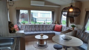 A compact living space with a sofa, a dining table, and a kitchen area. - RBR 244 - Beach Resort Kamperland (Kamperland)