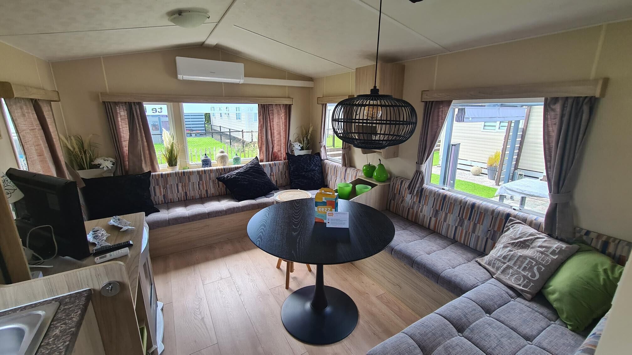 A cozy living room with a sofa, a round table, and a hanging light fixture.