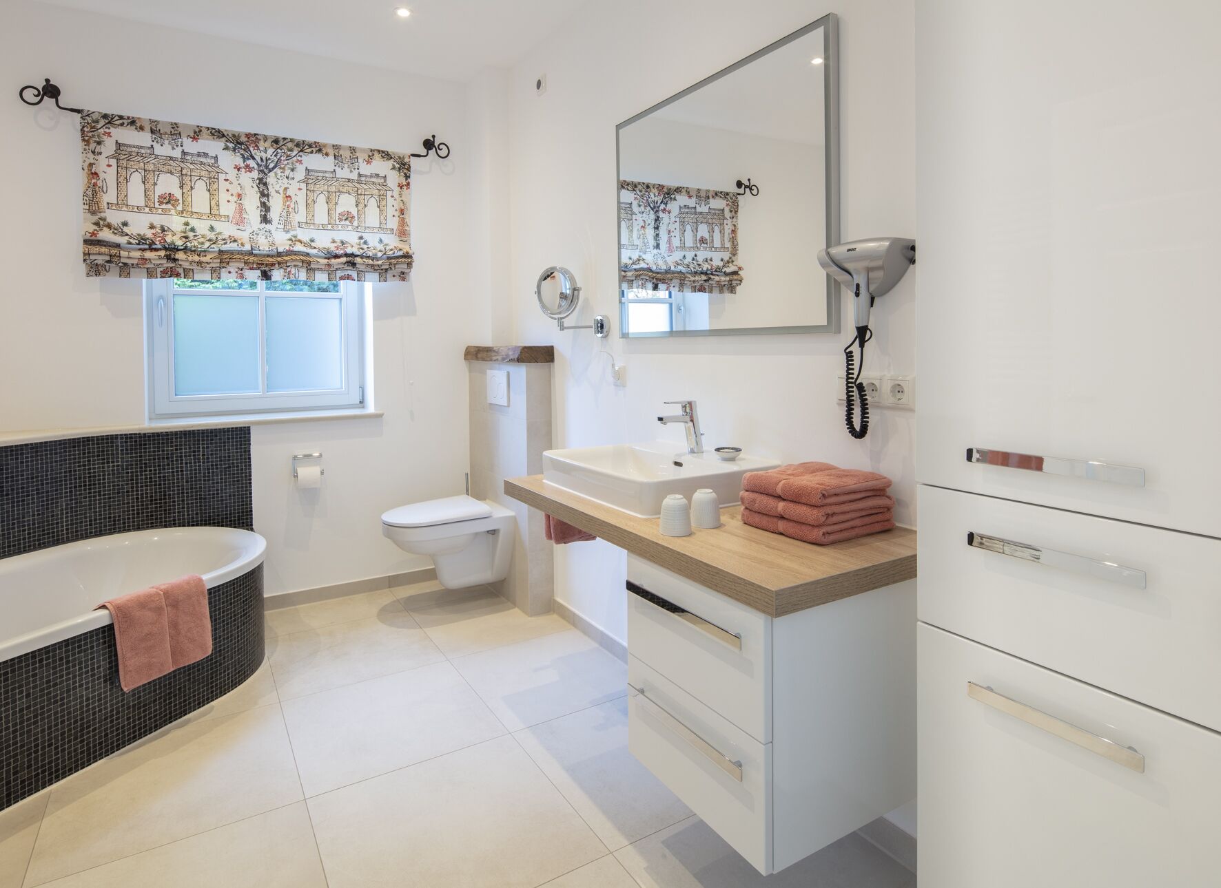 A modern bathroom with a bathtub, toilet, sink, and vanity.