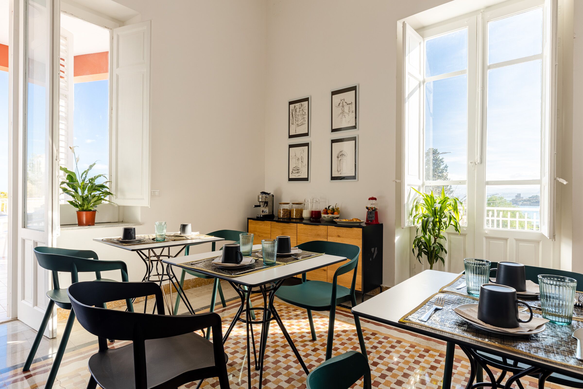 A dining area with a table set for four, chairs, a kitchen counter, and a window with a view.