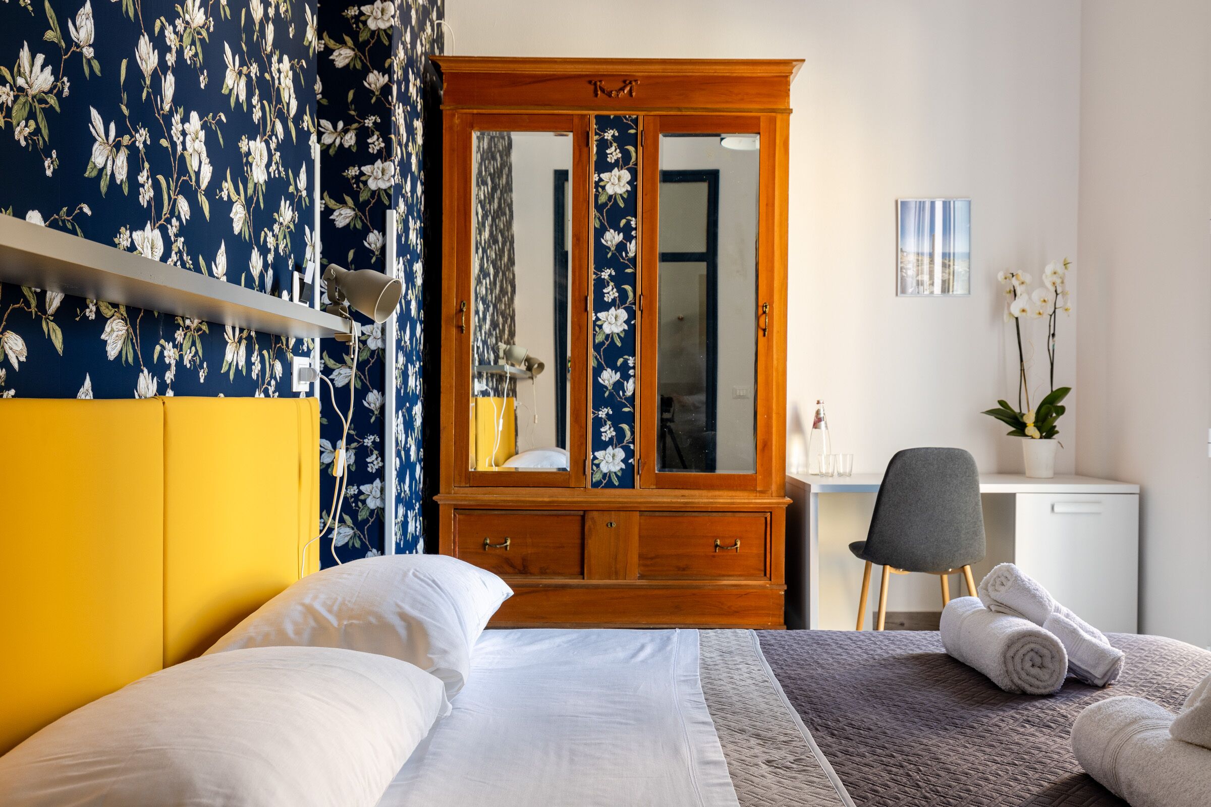 Une chambre à coucher avec un lit, une armoire en bois, un bureau et une chaise.