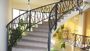 A staircase with a black metal railing, granite steps, and potted plants. - Nice Hotel Yerevan (Yerevan)