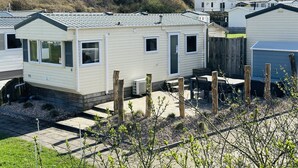 A row of mobile homes with a grassy hill in the background.