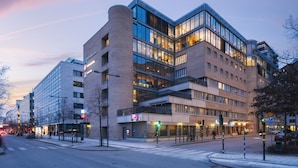 Een modern hotel met meerdere verdiepingen, grote ramen en een opvallende hoingang.