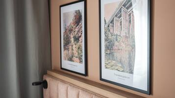 Two framed artworks on a wall above a cushioned bench.