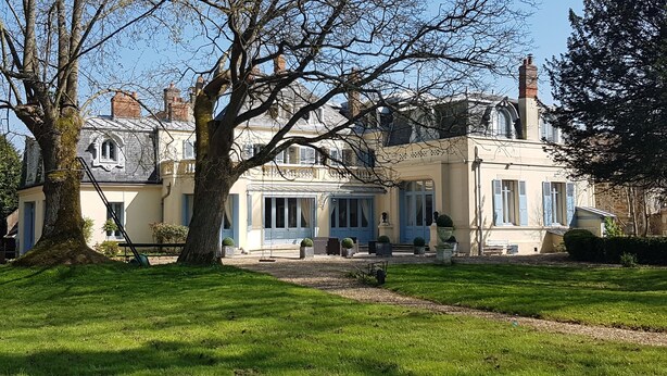 A large, historic building with multiple windows and a prominent tree in the foreground. - Cottage for 10 p max / Private swimming pool / Pond / Ideal location / Paris less 1 hour (La Chapelle-Rablais)