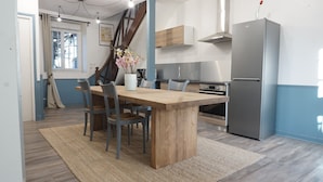 A modern kitchen with a wooden dining table, chairs, a refrigerator, and a stove. - Cottage for 10 p max / Private swimming pool / Pond / Ideal location / Paris less 1 hour (La Chapelle-Rablais)