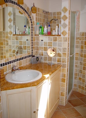 A bathroom with a sink, mirror, and shower. - Apartment With Sea View Terrace (La Maddalena)