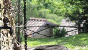 A rustic outdoor water feature with a stone basin and a hanging chain. - la Casetta Nel Bosco Feel the Nature (Vicchio)