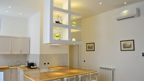 A modern kitchen with white cabinetry, a wooden countertop, and recessed lighting. - Ursa Major - Gioligio Rome Central Luxury Suite (Rome)