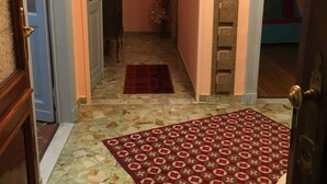 A hallway with a patterned rug, a door with a decorative handle, and a framed picture on the wall. - Fronte Po Torino, Foot Of The Hill - Non-smoking Only (Turin)