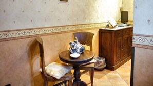 A dining area with a round table, chairs, and a cabinet. - Dependance Naples City Centre (Naples)
