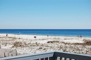 A beach with a wooden deck in the foreground.