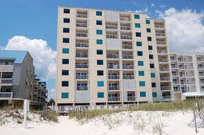 A multi-story hotel with balconies, located near a sandy beach. - Low Density Gulf Front Condo | Sleeps 6 (Gulf Shores)