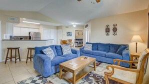 A living room with two sofas, a coffee table, and a ceiling fan.