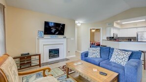 A living room with a fireplace, a television, a sofa, and a coffee table.