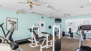 A gym with exercise equipment, ceiling fans, and a treadmill. - 2BR Gulf Shores Condo | Central Location + Short Drive to Beach (Gulf Shores)