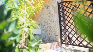 A stone wall with a metal gate, surrounded by greenery. - Studio 200 Meters From the Sea, Wifi, Self Catering (Sciacca)