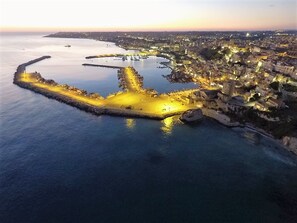 An aerial view of a coastal city with a well-lit harbor and a fortified peninsula. - Studio 200 Meters From the Sea, Wifi, Self Catering (Sciacca)