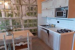 Apartamento família, 1 quarto, sacada, de frente para o mar (Laigueglia Beach) | Cozinha privada | Geladeira grande, micro-ondas, fogão, cooktop