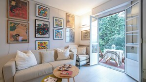 A modern living room with a sofa, coffee table, and a balcony with a table and chairs. - La Casa Al Sole Sea View 400mt From Sea (Andora)