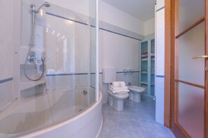 A modern bathroom with a glass-enclosed shower, a standalone toilet, and a bathtub. - La Casetta Sull'Albero child friendly (Albenga)
