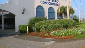 A building with a sign reading "Sugar Beach Condominium." - Sugar Beach 138 | Cozy Orange Beach Studio w Pool & Side Gulf View | Sleeps 4 (Orange Beach)
