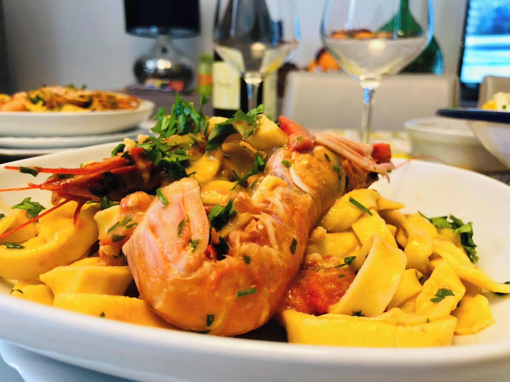 A lobster dish with mango chunks on a white plate.