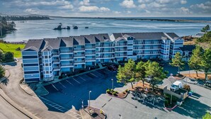 A multi-story hotel with a parking lot and a view of the water. - Stunning views from this bayfront condo in the Taft district of Lincoln City! (Lincoln City)