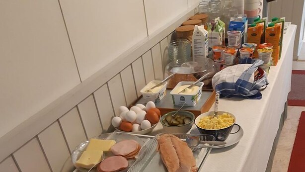 Una mesa de bufé con diversos alimentos, incluyendo carnes, quesos, frutas y verduras.