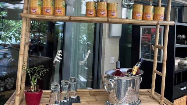 A bamboo structure with Havana Club cans and glasses, a potted plant, and a silver pitcher. - Hotel Hecht (Rheineck)
