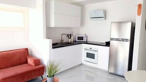 A modern kitchen with white cabinets, a stainless steel refrigerator, a microwave, and a sink. - Design 2 Bdr Apartment - Habima TL60 (Tel Aviv)