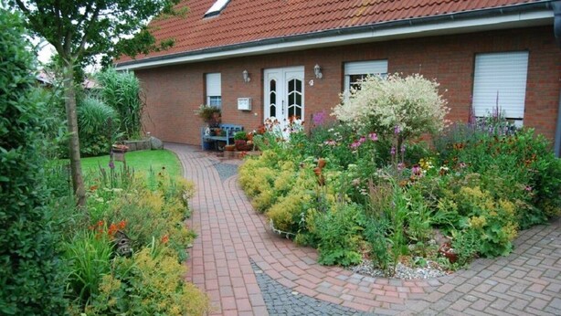 A brick house with a garden pathway leading to the entrance.