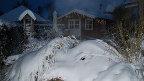 A house with a snow-covered roof and a porch.