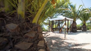 A gazebo with a roof, surrounded by palm trees and a gravel path. - Case Vacanza Renella 3 Beds Balcony, Wifi, Self-catering, 200mt From the sea (Valderice)