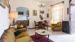 A living room with a sofa, dining table, chairs, and a fireplace. - Villa with 2 spacious apartments for 2 x 7 people and swimming pool near Pisa and the sea (Fauglia)
