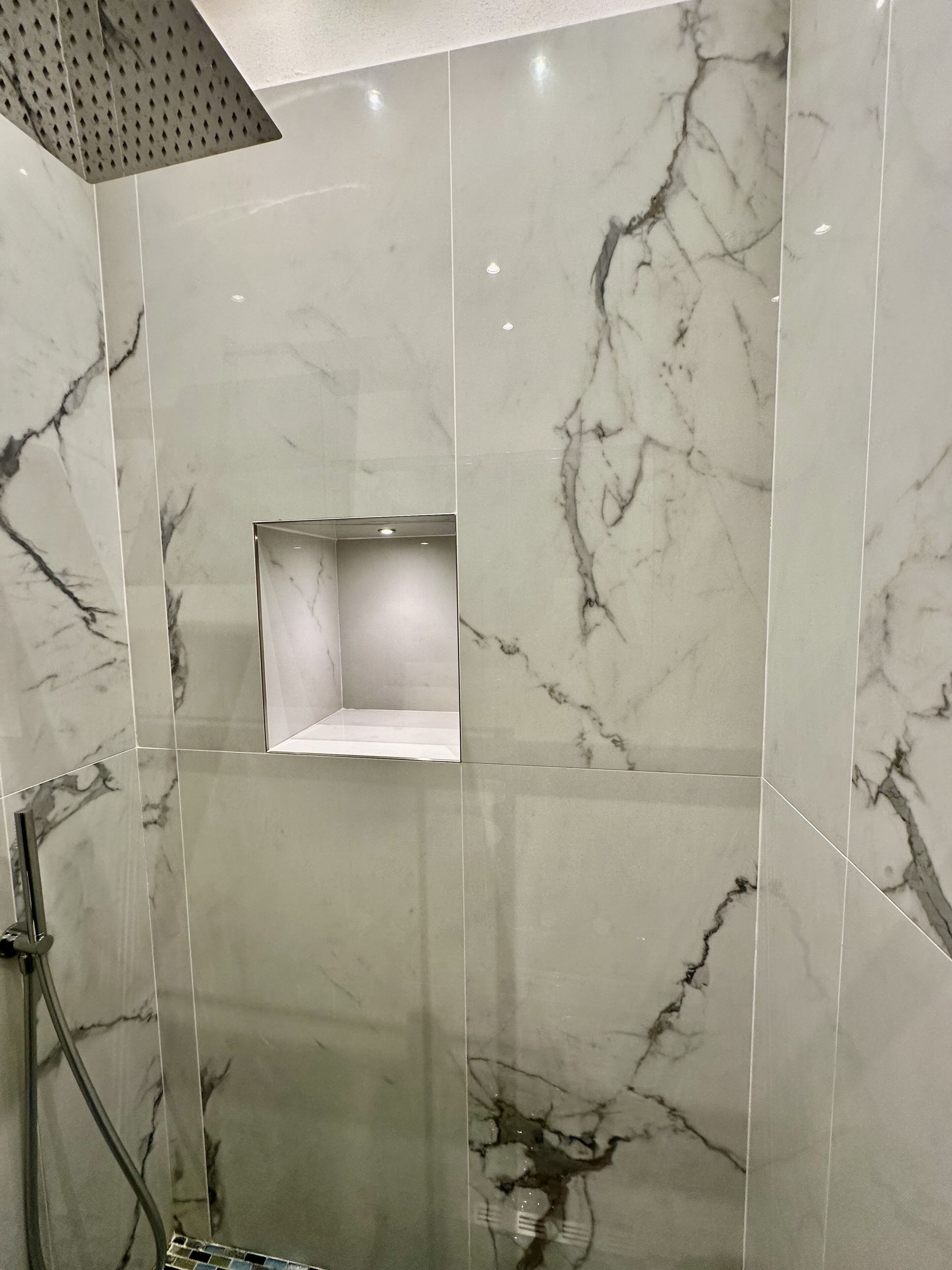 Une salle de bain moderne avec des carreaux de marbre et un espace douche.