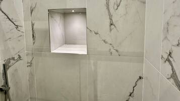 Une salle de bain moderne avec des carreaux de marbre et un espace douche.