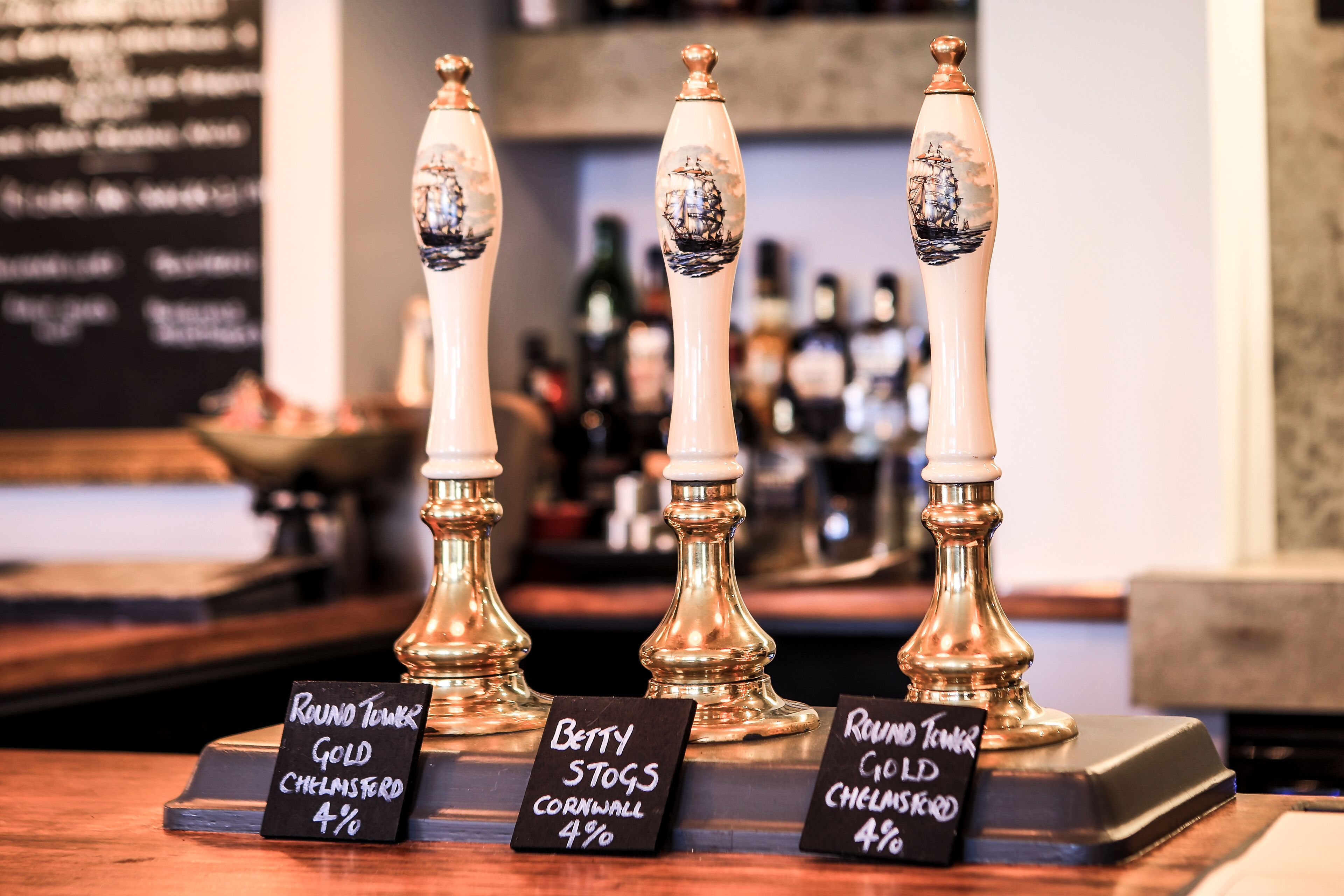 Three beer taps labeled with different beer names and percentages.