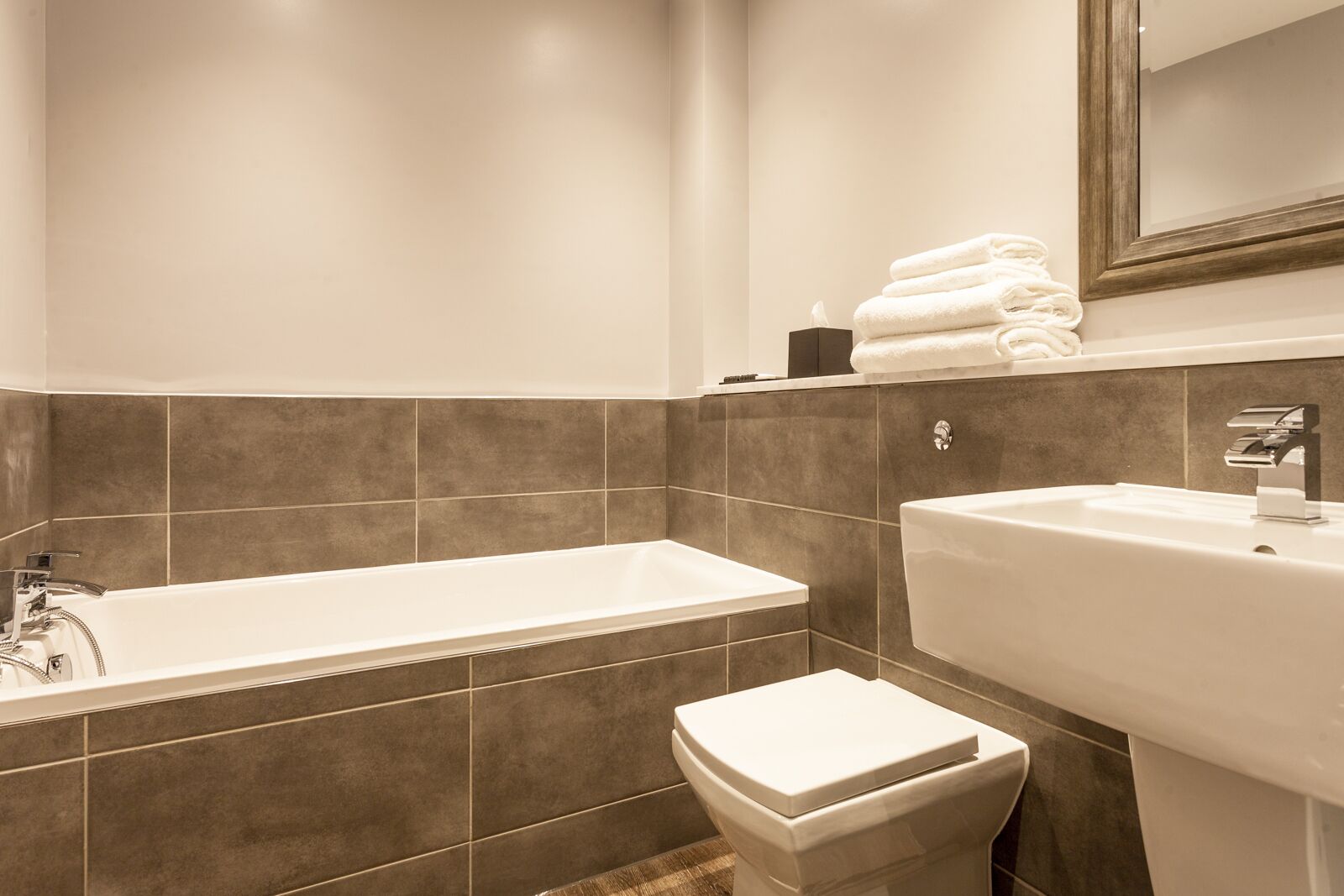 Ein modernes Badezimmer mit Badewanne, Waschbecken und Toilette.