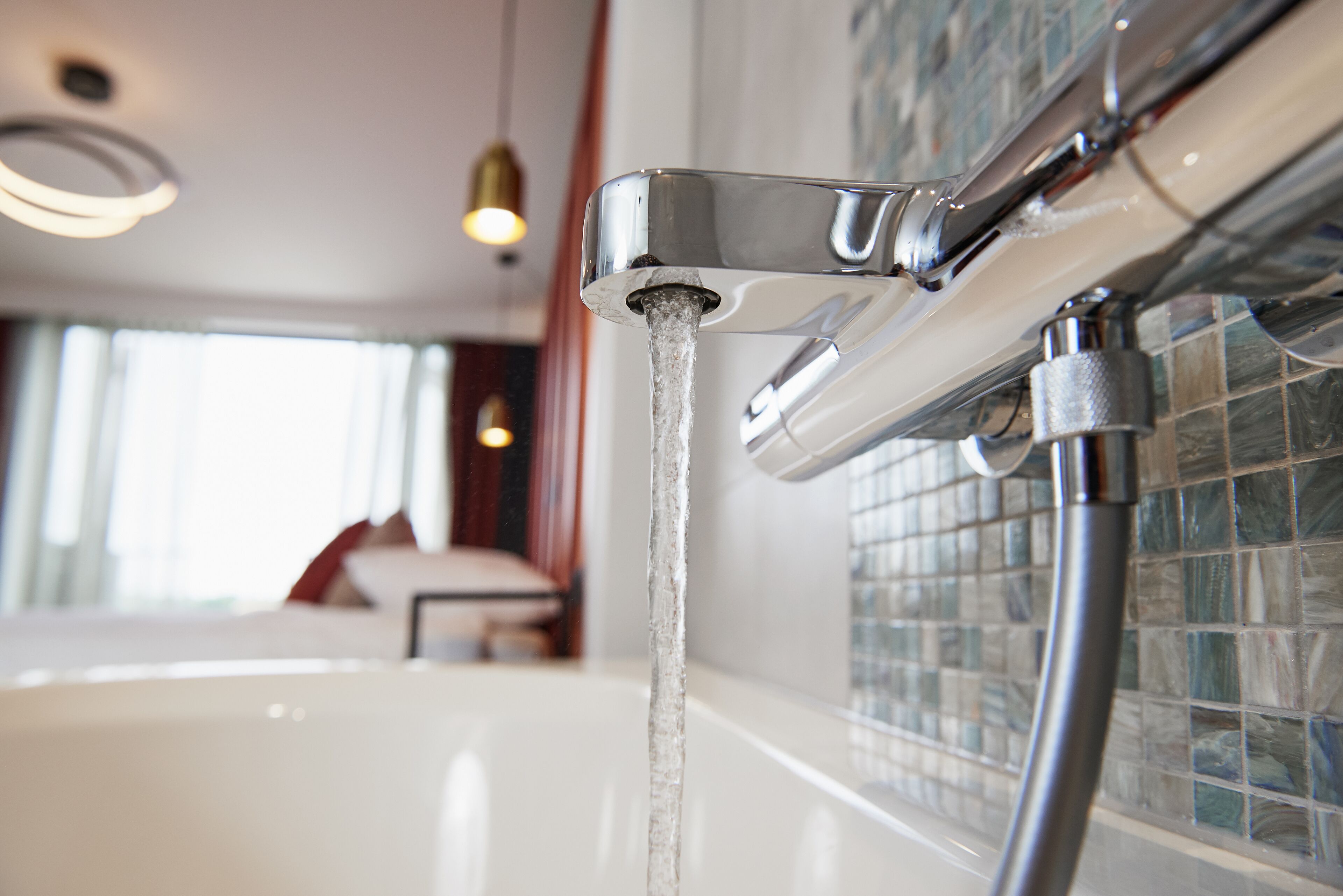 Un baño con un grifo moderno y agua corriente cristalina.