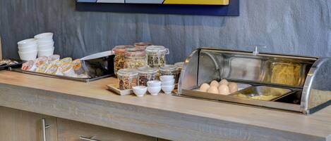 A breakfast buffet with various food items and containers.